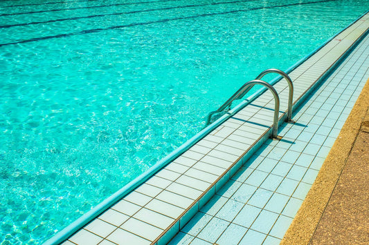 A bright blue swimming pool with safety ladder