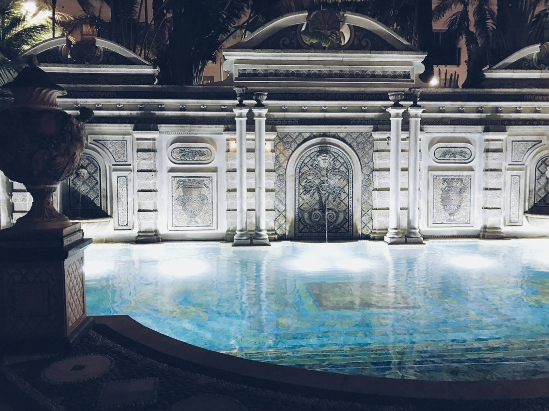 Pool in front of ornate building with bright underwater lights