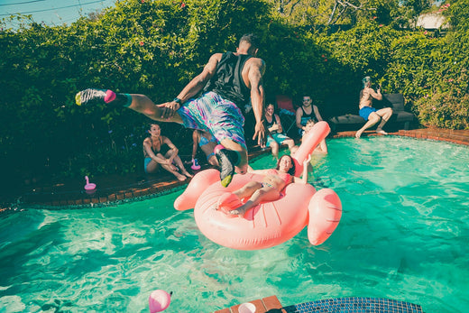 Man jumping into pool at pool party