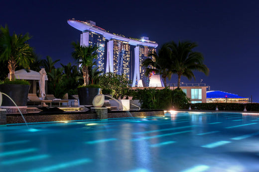 Closeup of illuminated bar with illuminated pool in background